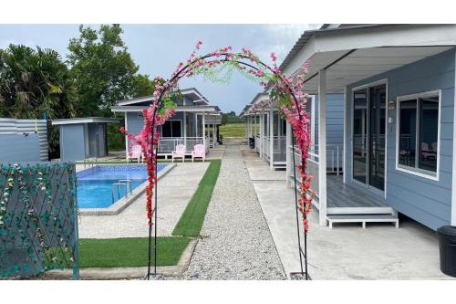 a home with a swimming pool and a house with a gate at Capital O 91228 Hureen Chalet Hmk in Kampung Kok Kelang