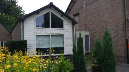 een wit huis met een raam en een bakstenen gebouw bij Vino Grando Cottage in Odiliapeel