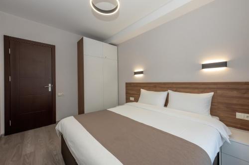 una camera da letto con un letto grande con lenzuola bianche di Crystal Resort a Bakuriani