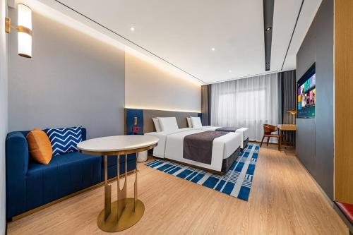 a hotel room with a bed and a couch at YUNlK Hotel in Harbin
