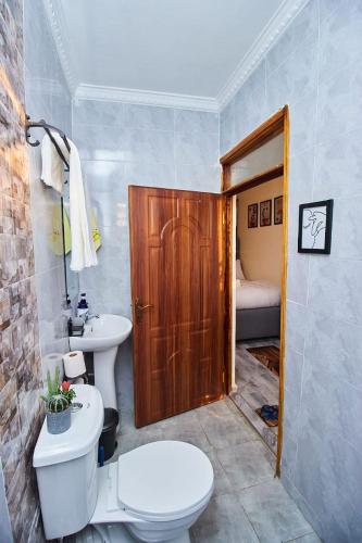 a bathroom with a toilet and a sink at Happy Homes Airbnbs- Kikuyu in Nairobi