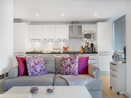 a living room with a couch and a kitchen at Pass the Keys Bright and cozy apartment in Kentish Town in London