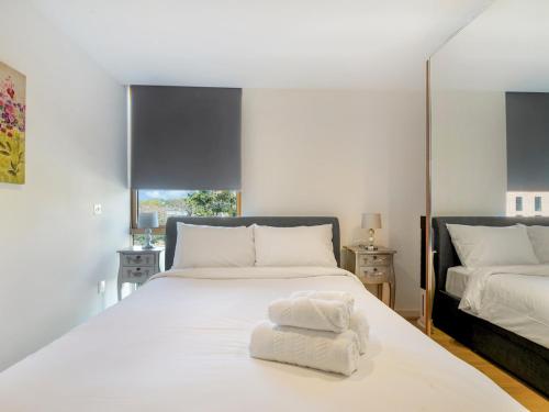 a white bed with a white towel on top of it at Pass the Keys Bright and cozy apartment in Kentish Town in London