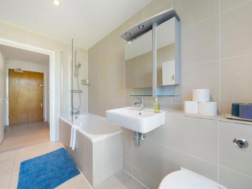 a white bathroom with a sink and a toilet at Pass the Keys Bright and cozy apartment in Kentish Town in London