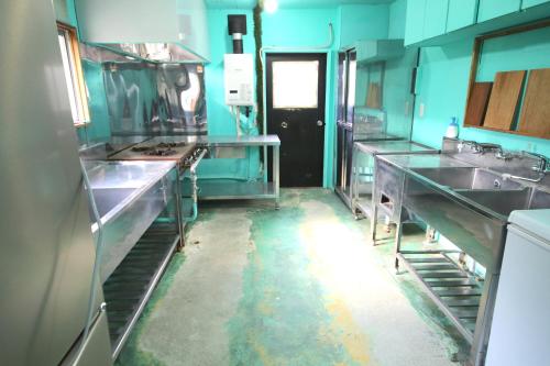 a large kitchen with a black door in the middle at Maple House in Myoko