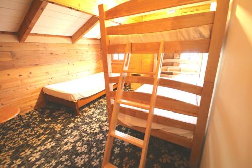 a room with two bunk beds and a bed at Maple House in Myoko