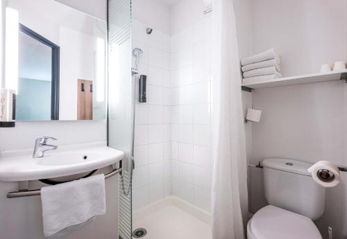a white bathroom with a toilet and a sink at B&B HOTEL Annemasse Est in Annemasse