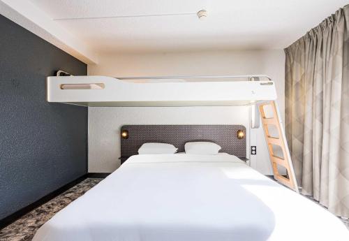 a room with two beds and a bunk bed at B&B HOTEL Annemasse Est in Annemasse