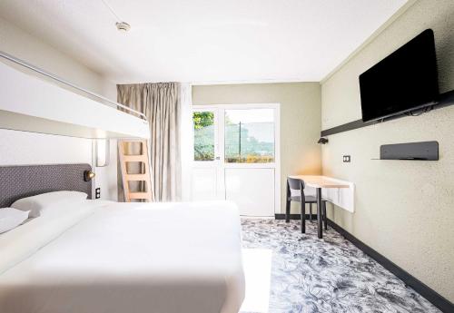 a hotel room with a bed and a desk at B&B HOTEL Annemasse Est in Annemasse