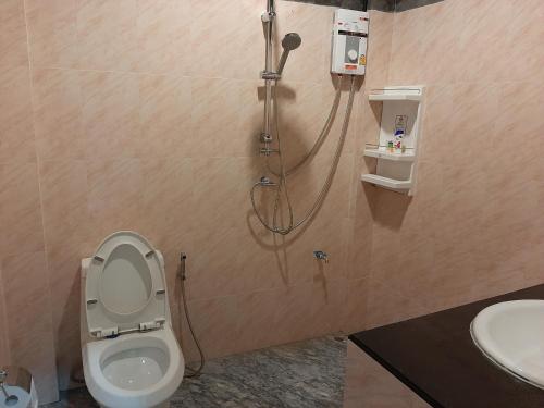 a bathroom with a shower with a toilet and a sink at Baan Berm Family Inn 