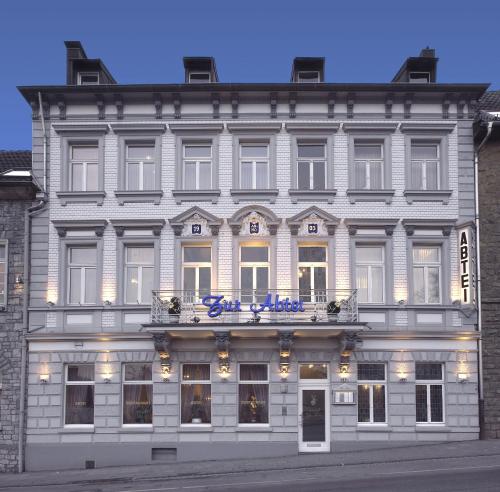 a large white building with a sign on it at Design-Hotel Zur Abtei in Aachen