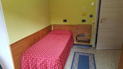 a small bedroom with a bed with a red comforter at Hotel San Marco BB in Boario Terme