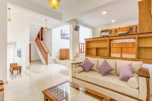 a living room with a couch and a glass table at Orchid Villa Kandy in Kandy