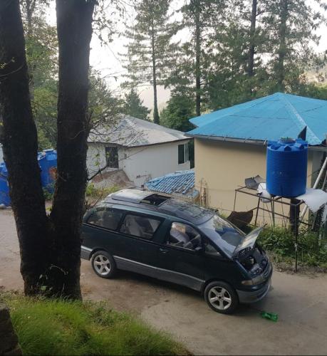 a black car parked next to a tree at Nabeel Hotel in Dargai