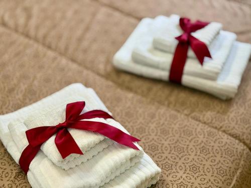 two towels with red bows sitting on a bed at Casa Telli - da Merilù in Turin