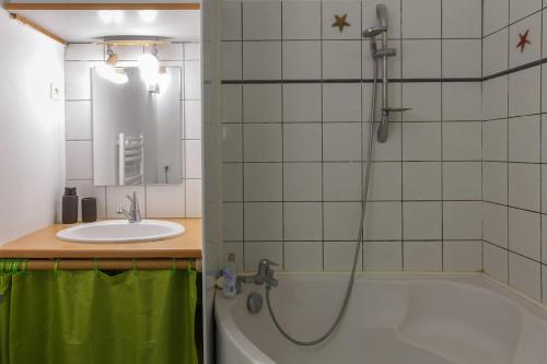 a bathroom with a tub and a sink and a shower at appartement entre plages et centre historique in Concarneau