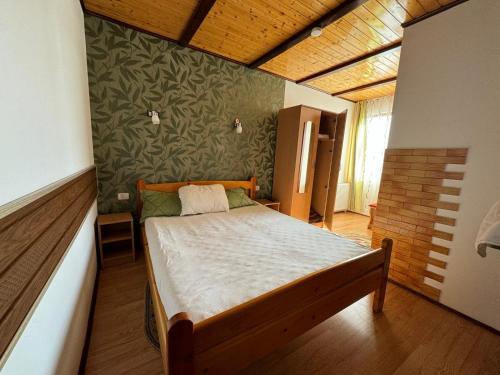 a bedroom with a bed and a green wall at Pensiunea Namaesti - Inchiriere integrala in Nămăeşti