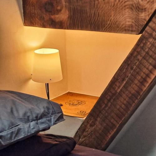 a bedroom with a bed and a lamp next to a table at Coume a Case - Gîte 4 étoiles - Charme et nature Vallée d Ossau in Lys