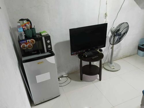 BocaueにあるZac's Lodging Bocaueのテレビ、小型冷蔵庫が備わる客室です。