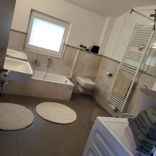 a bathroom with a sink and a toilet and a window at FeWo Planck OG 3 SZ in Buxtehude
