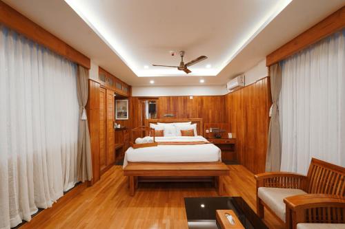 a bedroom with a bed and a couch and a table at Chandys Drizzle Drops - Munnar Top Station in Munnar