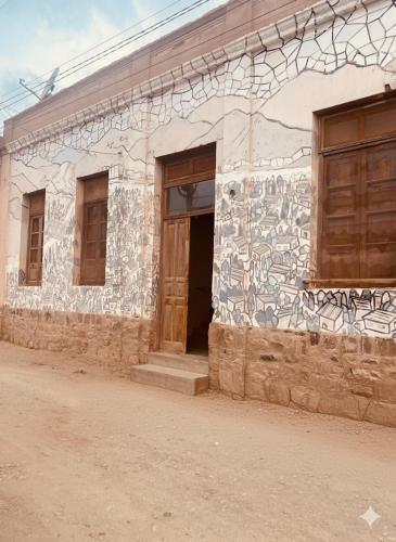 a building with graffiti on the side of it at Refugio Caro Cox in Tilcara