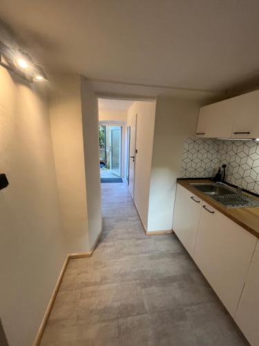 an empty kitchen with white cabinets and a hallway at Karlštejn 34 in Karlštejn