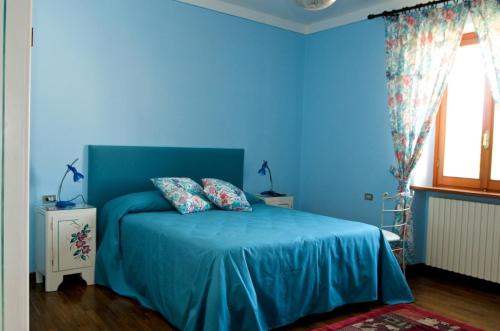 a blue bedroom with a blue bed with two pillows at Arco di San Francesco in Atri