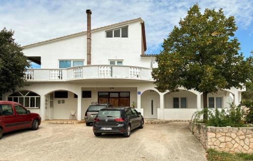 a white house with two cars parked in a driveway at 1 Bedroom Lovely Apartment In Krusevo in Kruševo