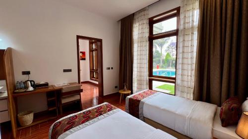 a hotel room with two beds and a window at Uyoga House in Arusha