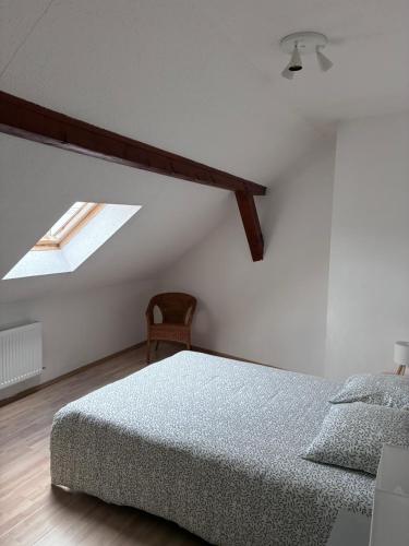 a white bedroom with a bed and a skylight at Colmar charmant logement in Colmar