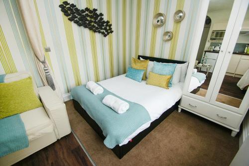 ブライトン＆ホーブにあるBetween Piers - Central- by Brighton Holiday Letsの鏡付きのベッドが備わる小さなお部屋です。