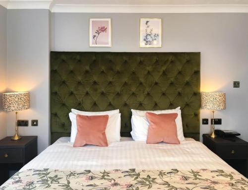 a bedroom with a large bed with pink pillows at Hotel Collingwood BW Signature Collection in Bournemouth