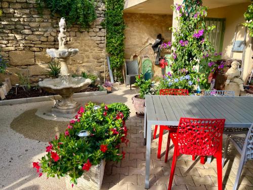 a garden with a table and flowers and a fountain at locastillon in Castillon-du-Gard