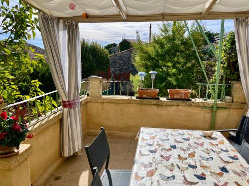 a table and chairs on a balcony with a view of a garden at locastillon in Castillon-du-Gard