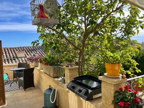 a balcony with potted plants and a tree at locastillon in Castillon-du-Gard