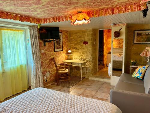 a bedroom with a bed and a table in a room at locastillon in Castillon-du-Gard