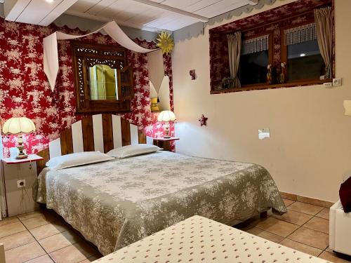 a bedroom with a bed and two tables and a mirror at locastillon in Castillon-du-Gard