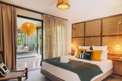 a bedroom with a large bed and a balcony at Domaine du Cap Sauvage in Saint-Joseph