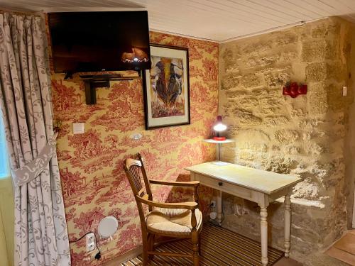 a room with a table and a chair and a desk at locastillon in Castillon-du-Gard