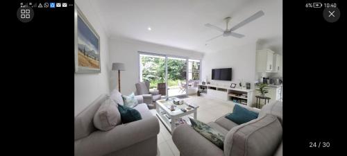 a living room with two couches and a tv at LaPeroge Home in Ballito