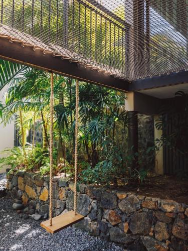 a porch with a swing in front of a building at Domaine du Cap Sauvage in Saint-Joseph