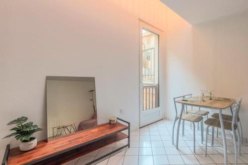 Un comedor con una mesa y un espejo. en Le Central, en Thonon-les-Bains
