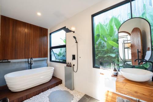 a bathroom with two sinks and a large mirror at Lavilaya Villa in Kerobokan