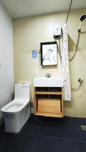a bathroom with a sink and a toilet at Spiral Suites Hotel in Manila