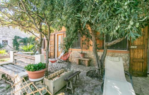 a backyard with a bench and a table and trees at Pet Friendly Home In Ragusa With Wifi in Ragusa