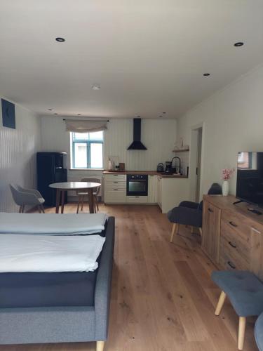 a bedroom with a bed and a table and a kitchen at ALTE SCHEUNE Ferienwohnungen - Wohnung 1 in Suderburg