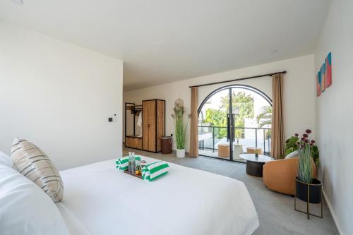 a bedroom with a white bed and a large window at Lavilaya Villa in Kerobokan