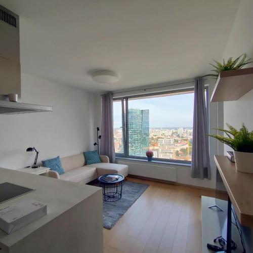 a living room with a couch and a large window at Sky Park 26th floor free parking free Wi-Fi in Bratislava