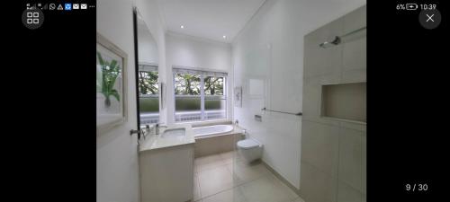 a bathroom with a sink and a toilet and a window at LaPeroge Home in Ballito